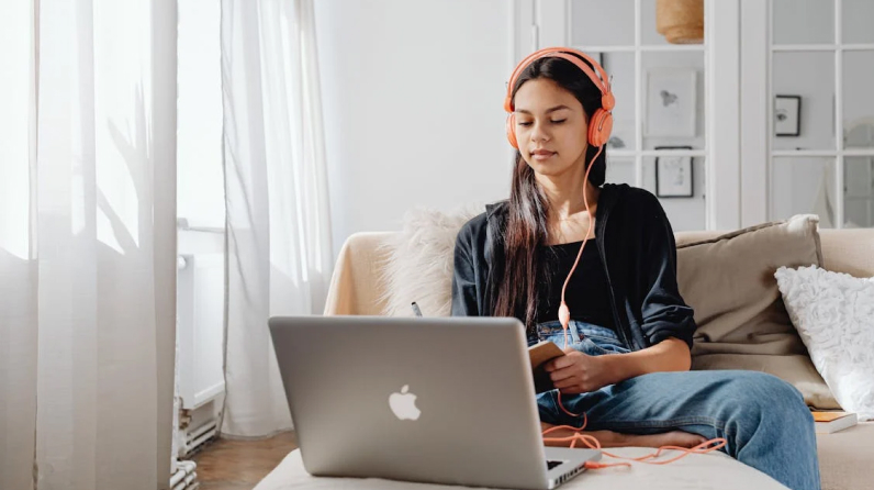 a girl in headphones at a laptop