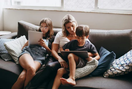 The family is sitting on the sofa